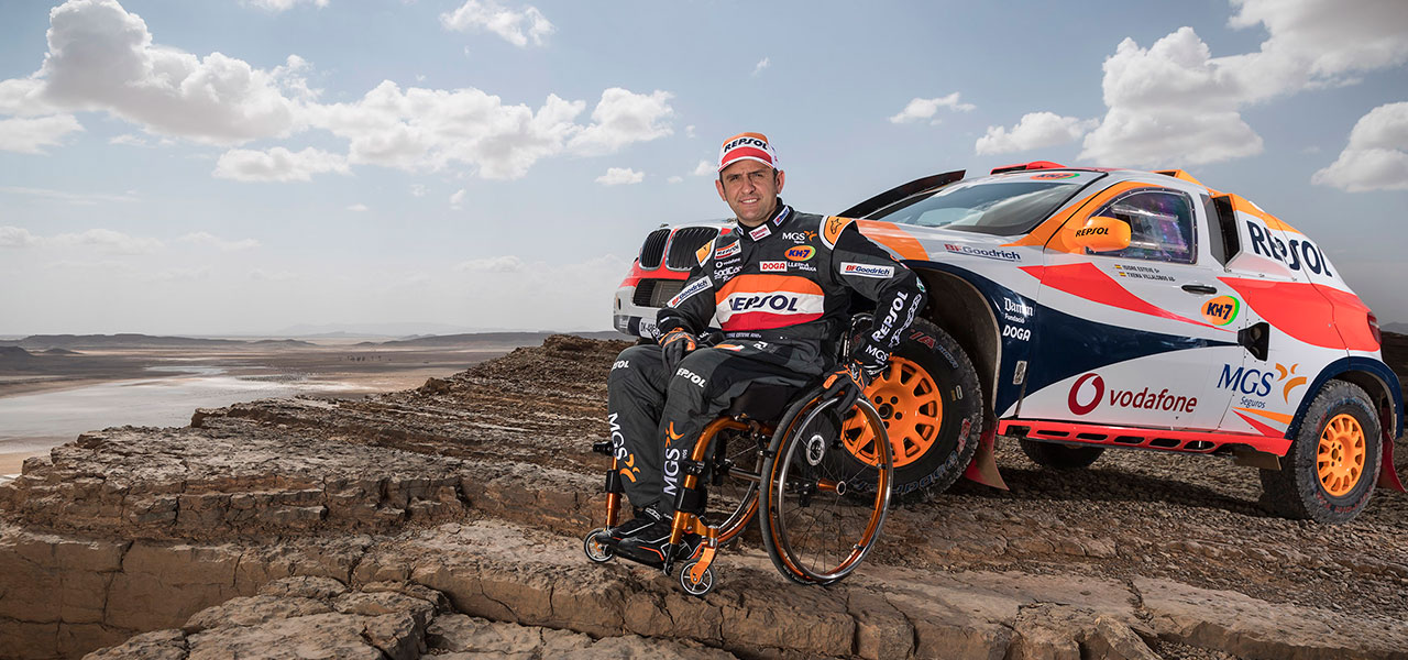 Isidre Esteve con su coche de rally en formación rocosa